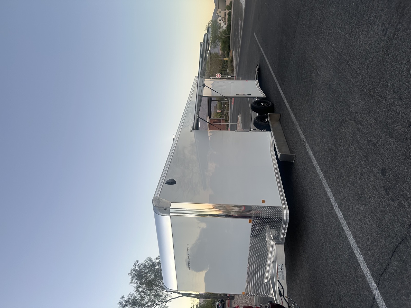 Enclosed auto trailer rental near me — side escape door open for loading
